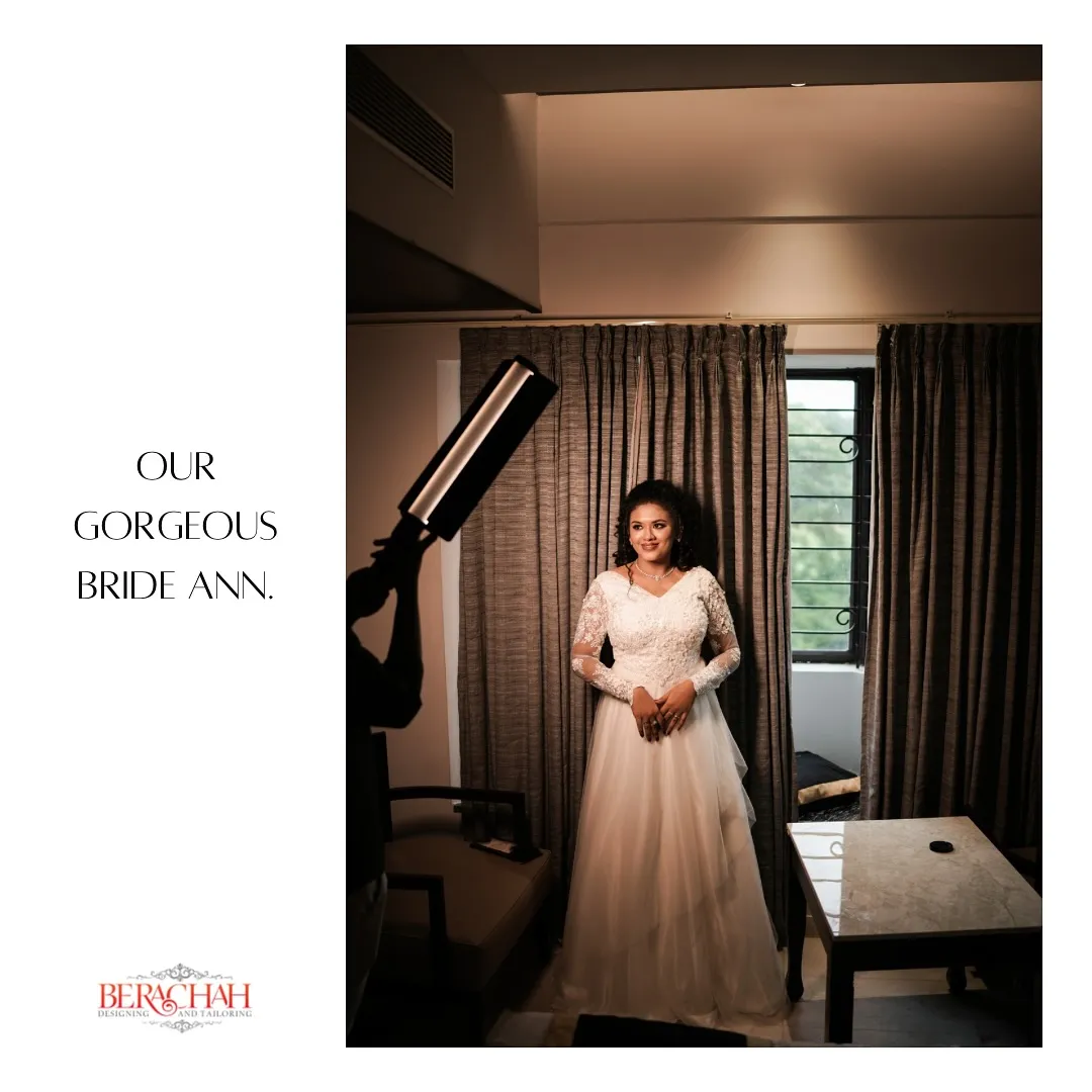 Bride standing in a white gown in a hotel suite