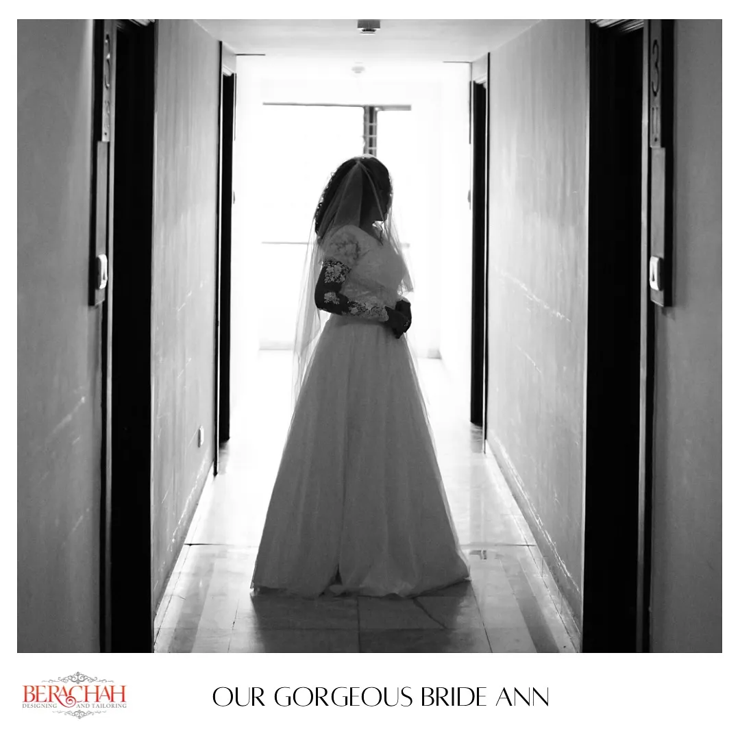 Black-and-white silhouette of a bride in a tulle gown in a corridor
